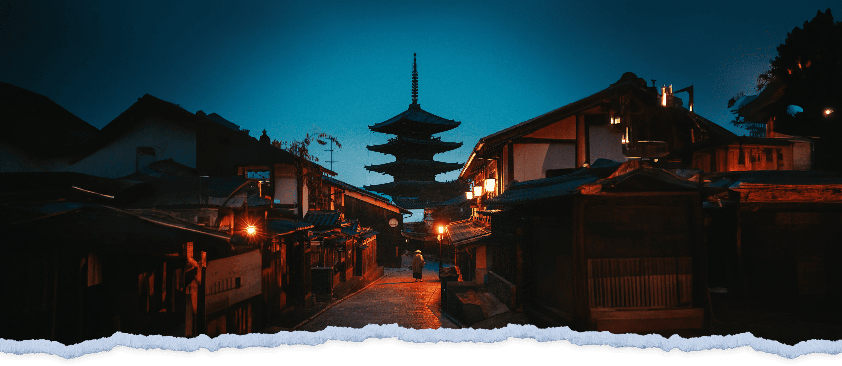 Nighttime view of a traditional Japanese street with a five-tiered pagoda towering in the background and illuminated houses lining the street.